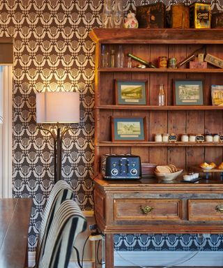 Maximalist wallpaper with authentic accessories on a wooden shelf