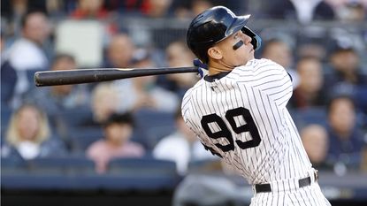 Aaron Judge of the New York Yankees hits a home run during a baseball game.