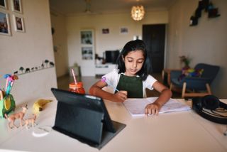 Young girl attending online school as schools close early for Christmas
