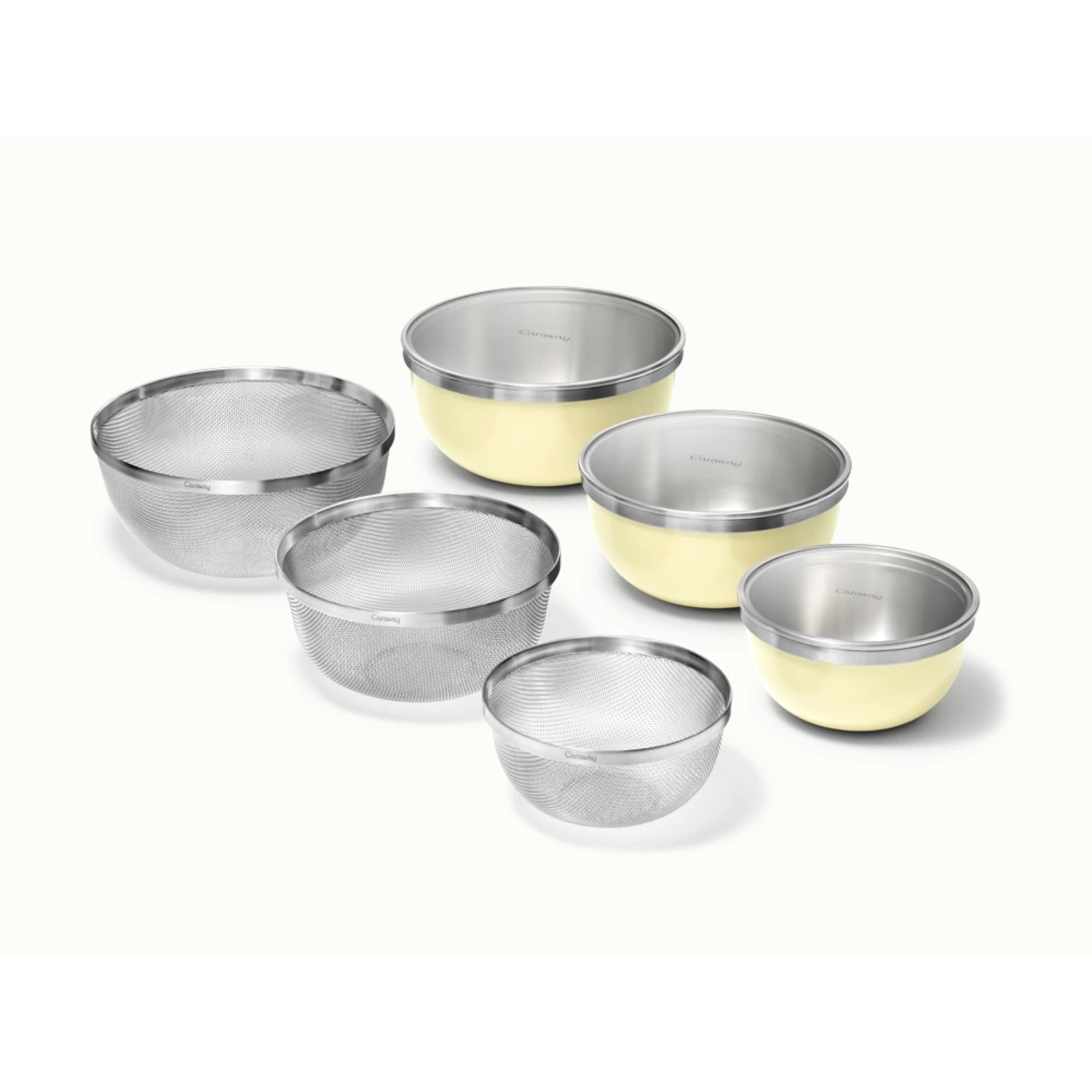 A set of three yellow mixing bowls with glass lids, beside three same size strainers