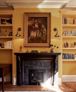 living room with gold-yellow walls, black fireplace and traditional artwork