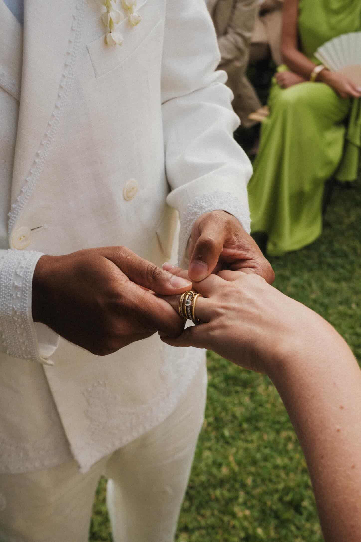 a close up of morgan elizabeth hall's hand with her spinelli kilcollin engagement ring and wedding band