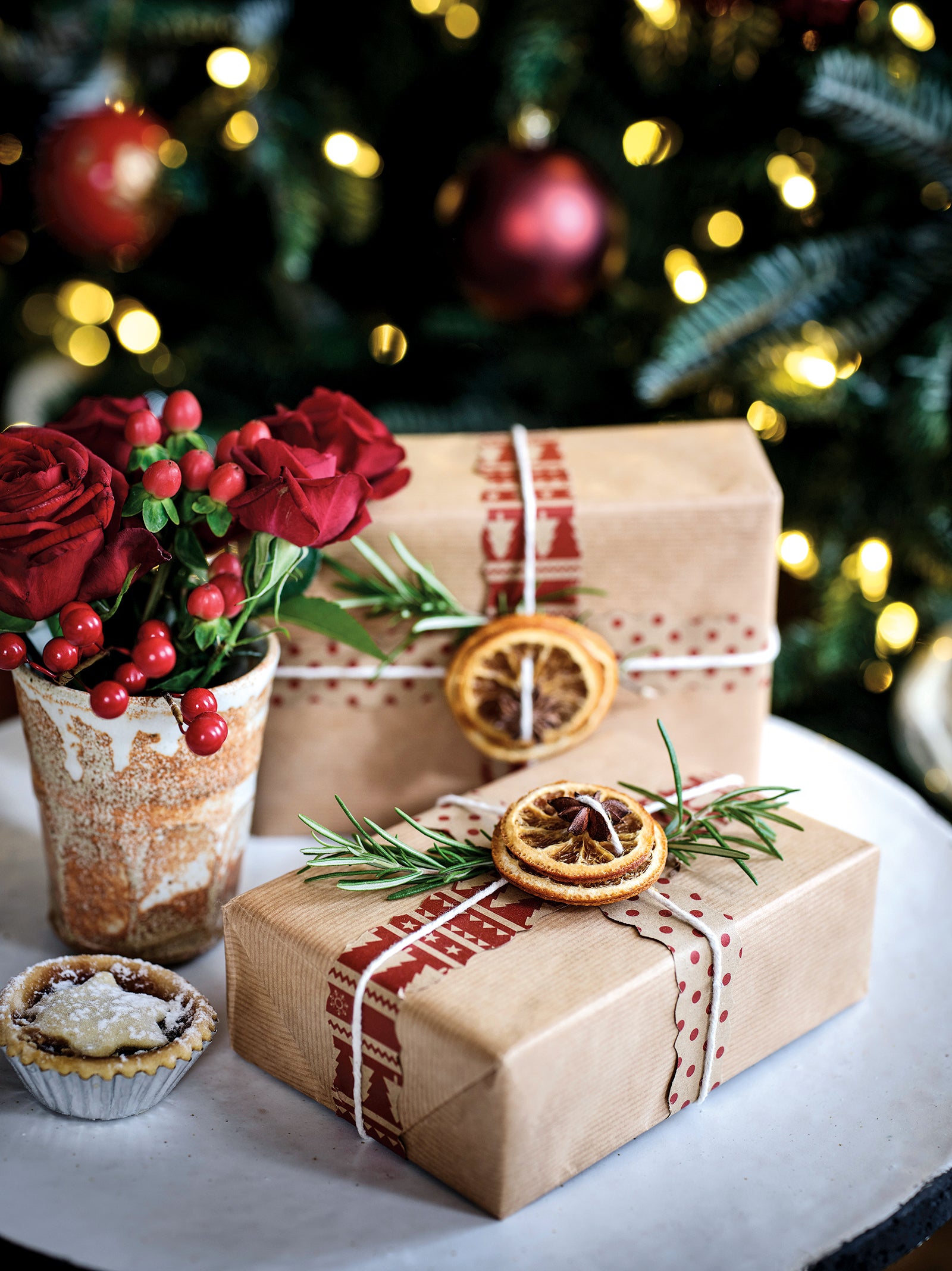 Gifts wrapped in brown paper and embellished with citrus fruit slices and rosemary
