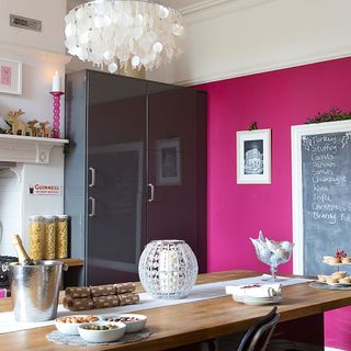 kitchen room with rose pink wall wooden table