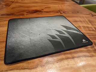 The Corsair MM300 mouse pad on a wooden table