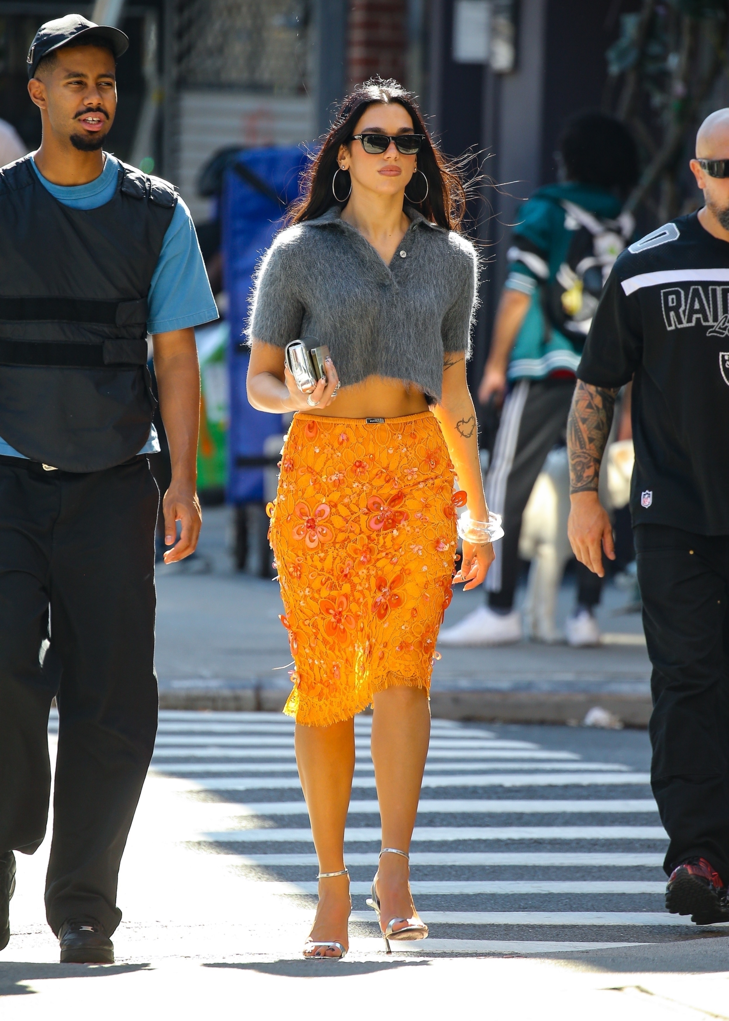Dua Lipa was spotted in NYC wearing an orange Gucci skirt and a fur polo shirt