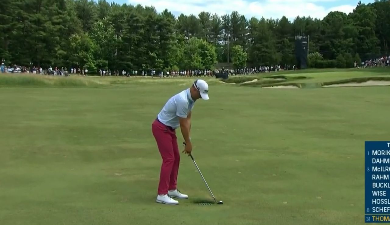 Thomas stands over his shot whilst the ball rests near a drain