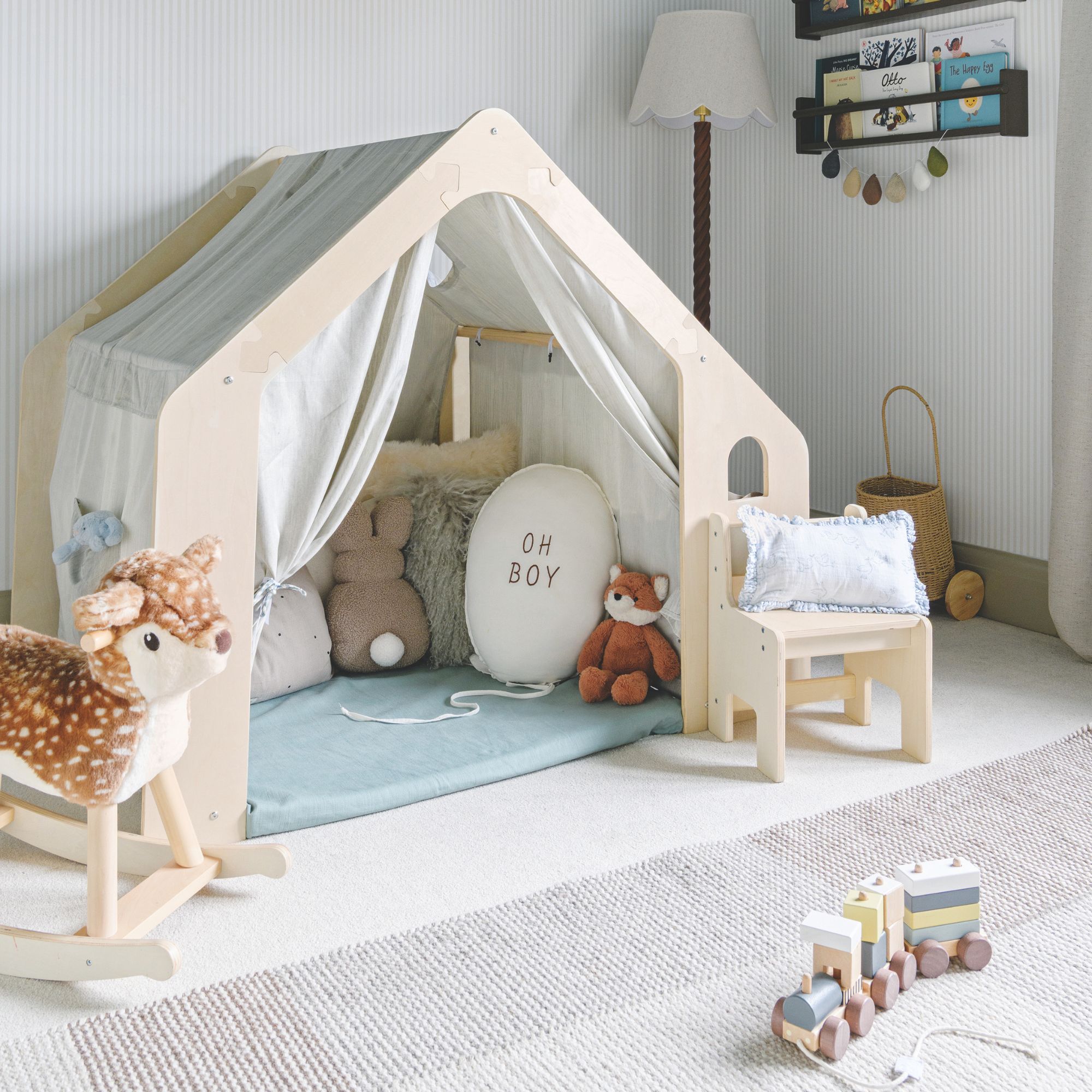 Boy&#039;s playroom with a play den on the floor, filled with toys