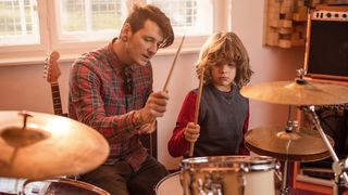 Man showing child how to play the drums