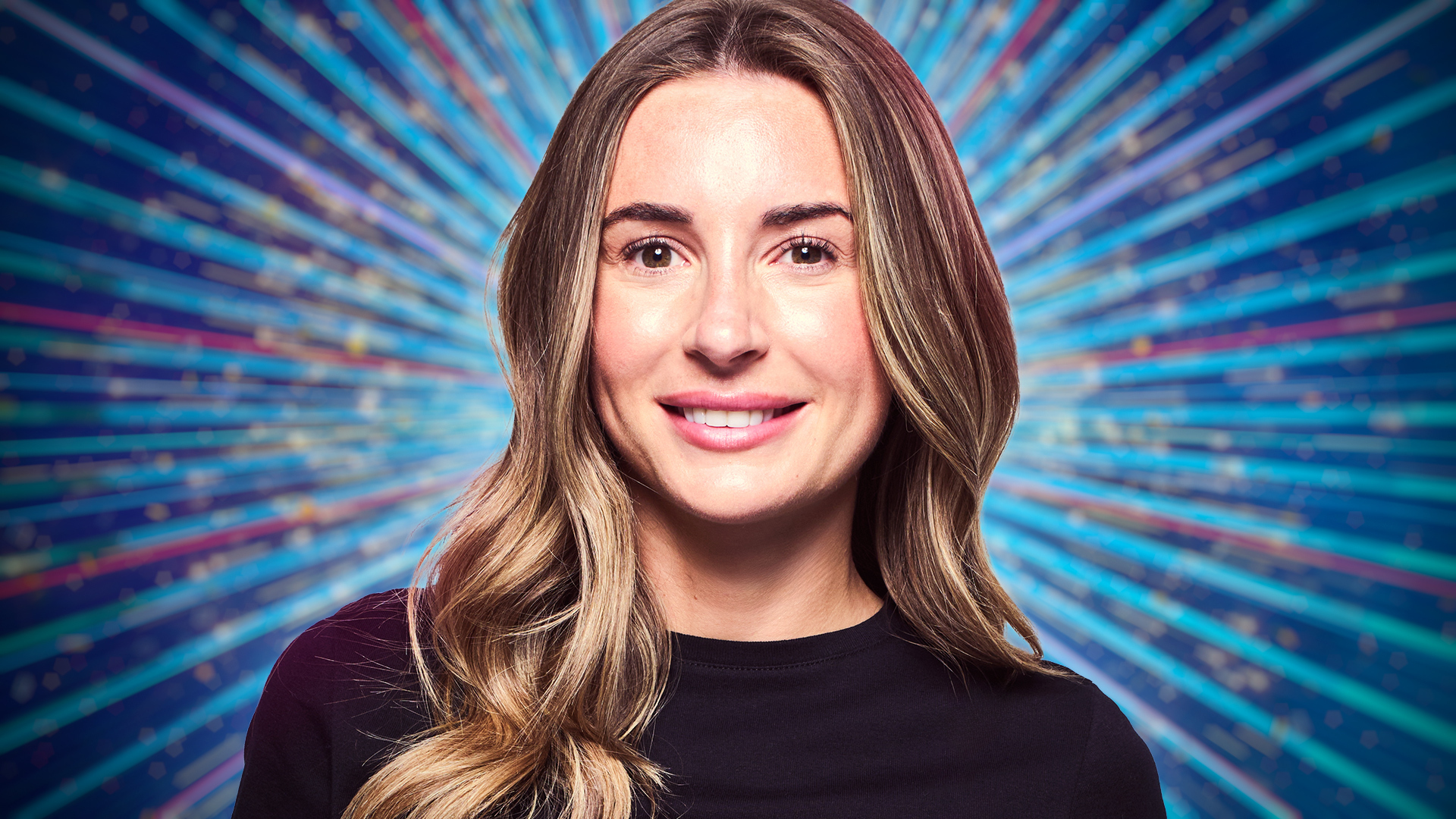 Dani Dyer smiling for the camera with a blue sparkly background behind her.