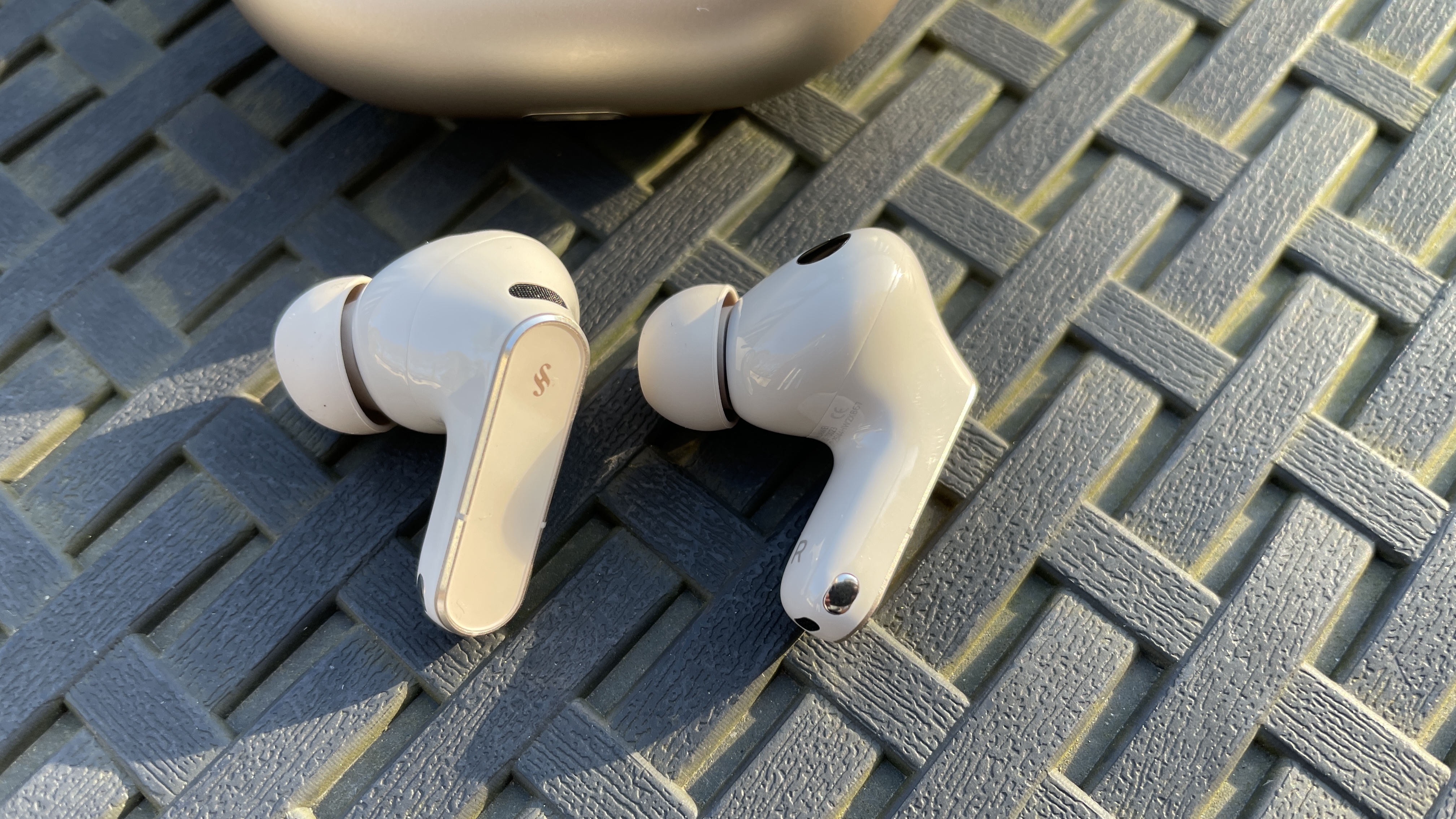 سماعات Huawei FreeBuds Pro 5 في الخارج، بالقرب من بعض أزهار النرجس البري، في شمس الظهيرة