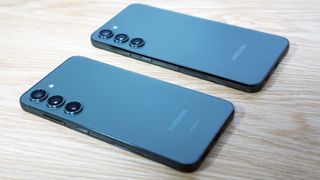 The Samsung Galaxy S23 Plus in the foreground, and the Galaxy S23, both in navy laying face down on a table