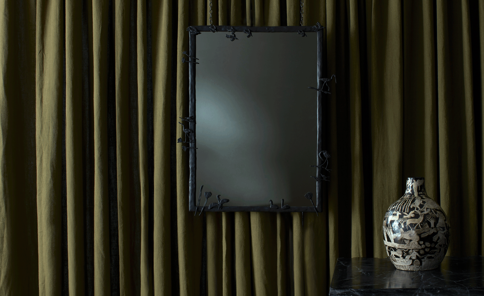 Dark mirror on a green curtain