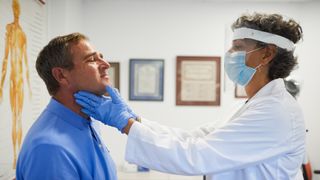 A doctor examines her patient's thyroid gland, which is an important part of the endocrine system. 