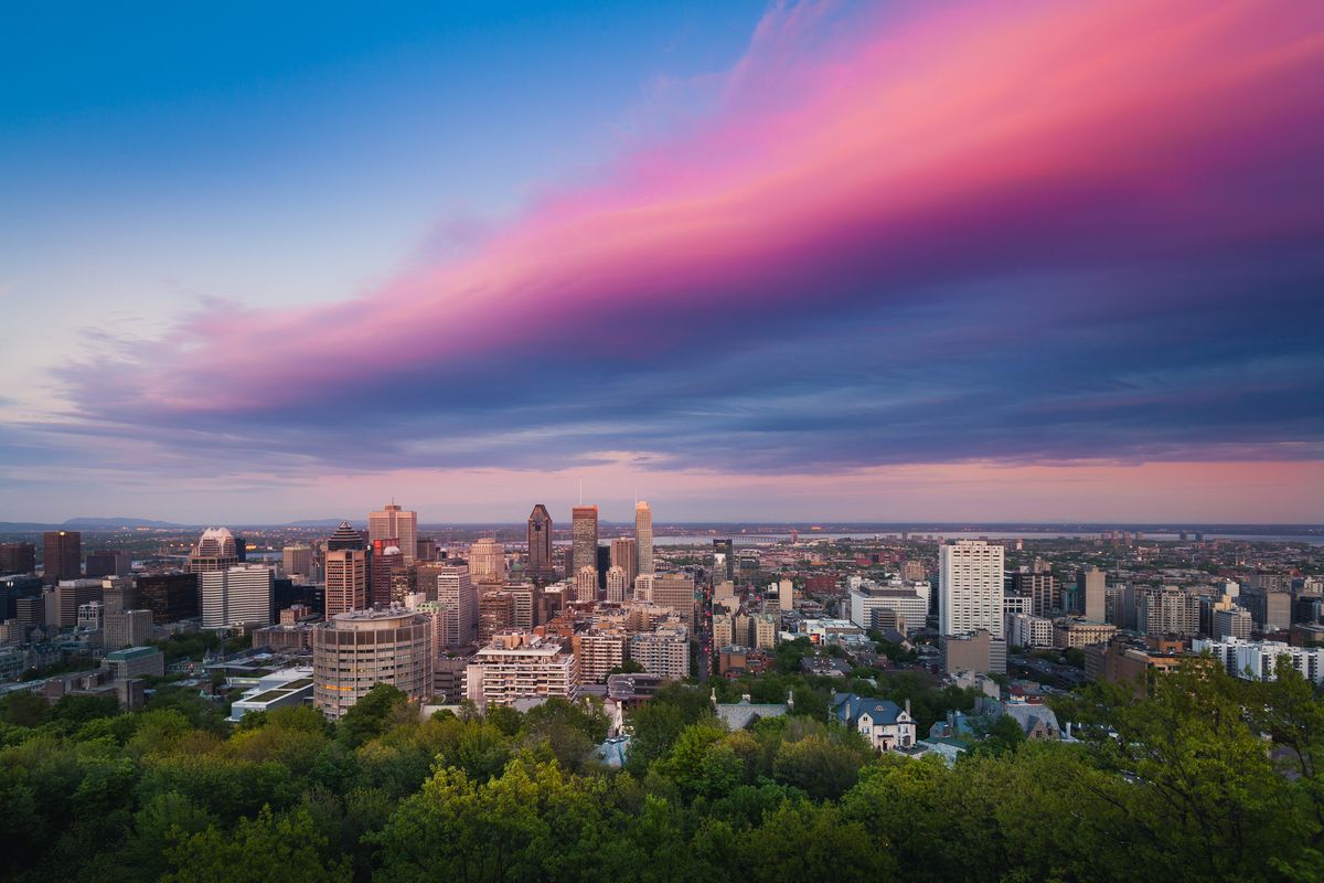 A view of the city of Montreal in Quebec, Canada, showing pink clouds covering the city