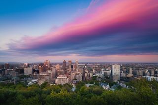 A view of the city of Montreal in Quebec, Canada, showing pink clouds covering the city