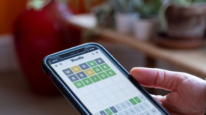 Beefy - Phrazle takes Wordle to the next level, here a woman plays Wordle on her smartphone from the living room of her home using just three guesses