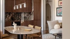 A mod small kitchen with a stone backsplash attached to an open dining and living room