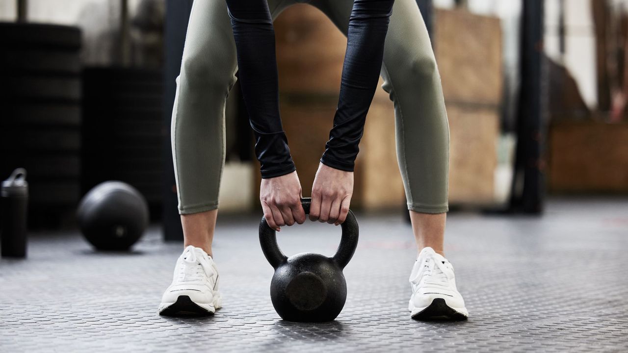 A woman doing 30 minute kettlebell workouts in the gym