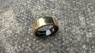 The Luna Ring 2 in Sunlit Gold against a concrete surface