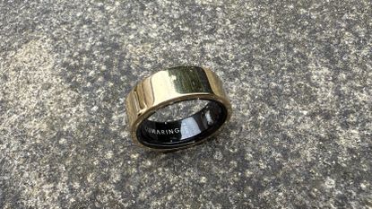 The Luna Ring 2 in Sunlit Gold against a concrete surface