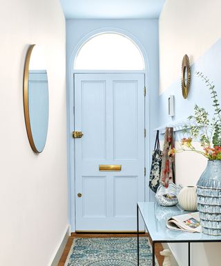 Blue painted front door and ceiling in cream hallway