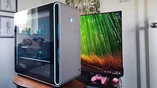 Alienware Area-51 gaming PC on coffee table with TV in in backdrop.