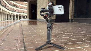 A wide shot showing the Hohem iSteady M7 mounted on its mini tripod legs