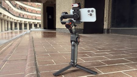 A wide shot showing the Hohem iSteady M7 mounted on its mini tripod legs