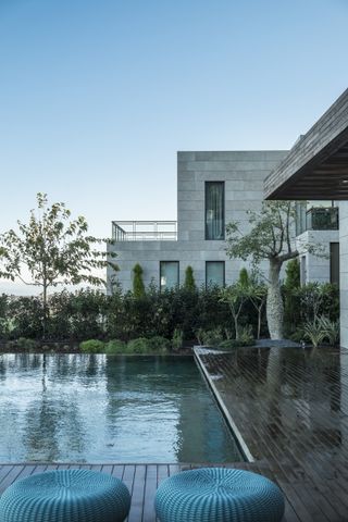Stone clad modernist house and terrace with outdoor swimming pool