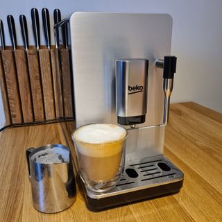 Beko CEG5311X Bean to Cup coffee machine with cup of coffee with frothed milk