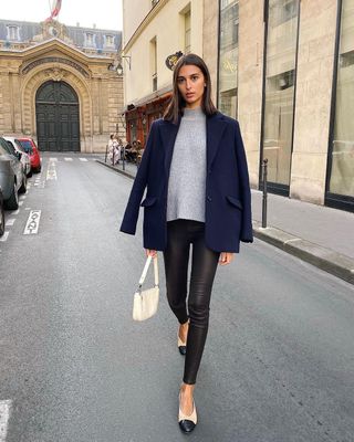 Salome wears a high-neck knit, leggings, a blazer and ballet flats