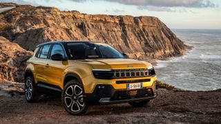 yellow jeep avenger parked by a cliff on the coast