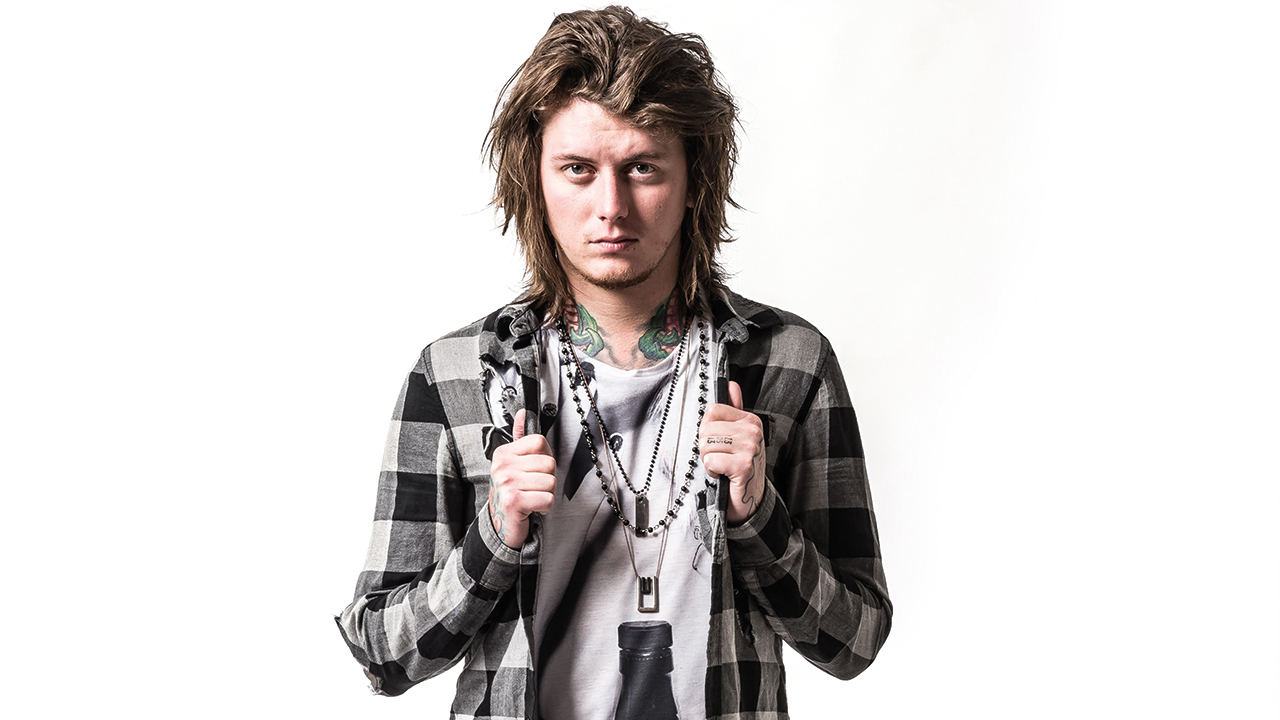 A portrait of Asking Alexandria&#039;s Ben Bruce looking into the camera