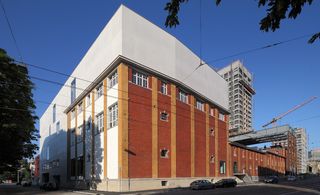 Red brick building with white concrete extension