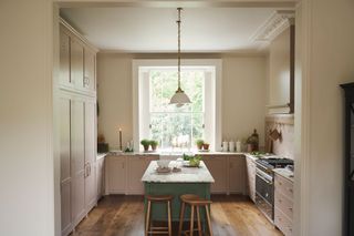 a pink and green devol kitchen in a south london house