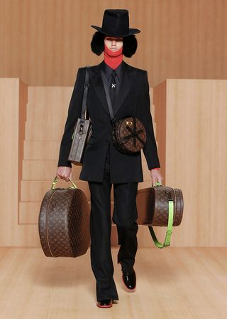 Male Model Wearing & Carrying Luggage Cases Designed by Louis Vuitton