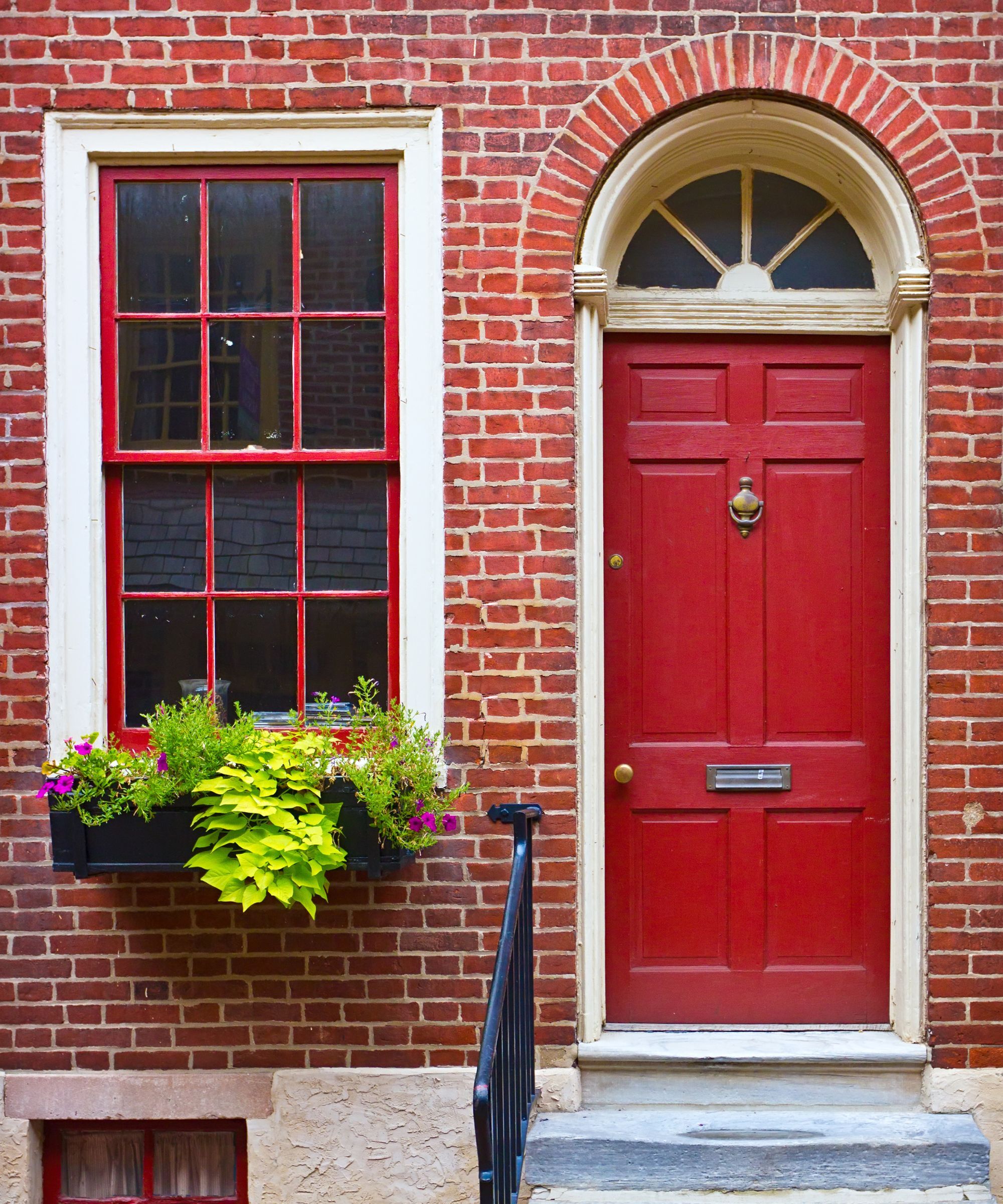A red brick house with a red front door
