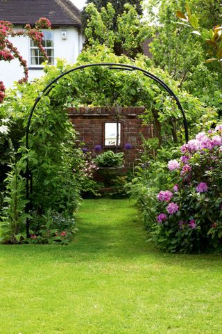 long garden ideas: archway and mirror on far wall