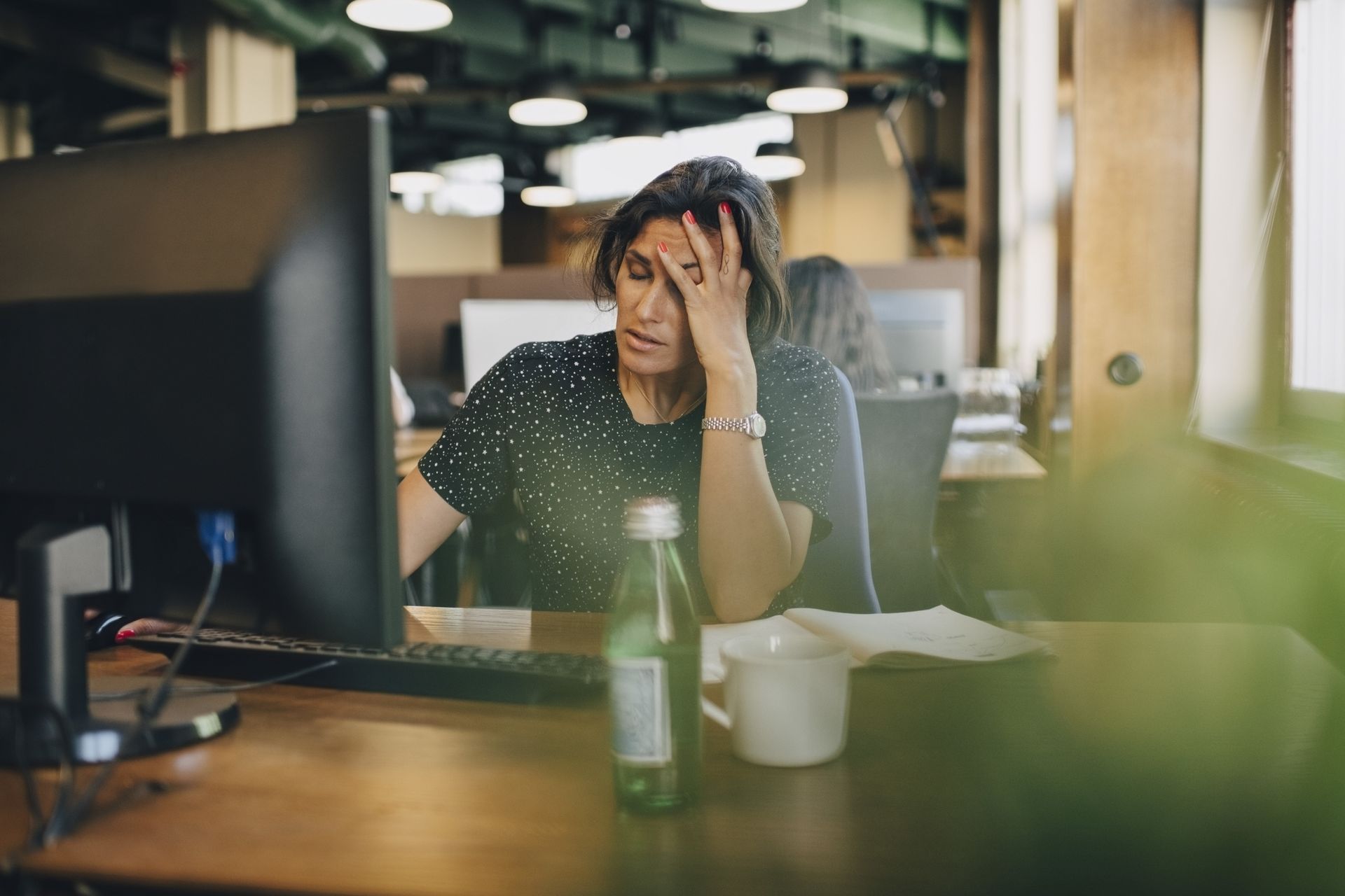 Workplace stress: A woman looking stressed at her desk