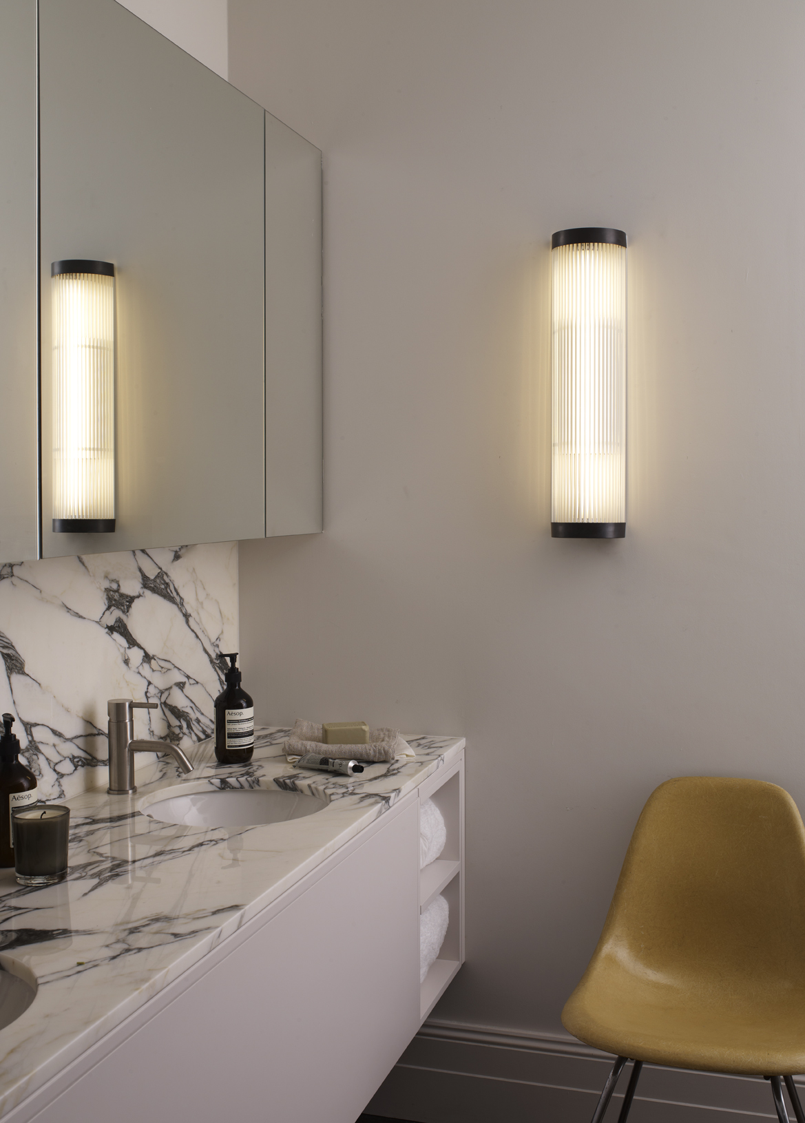 marbled sink space with basin and large mirror and light