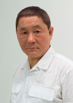 Portrait photography of Takeshi Kitano in a white shirt against a white background