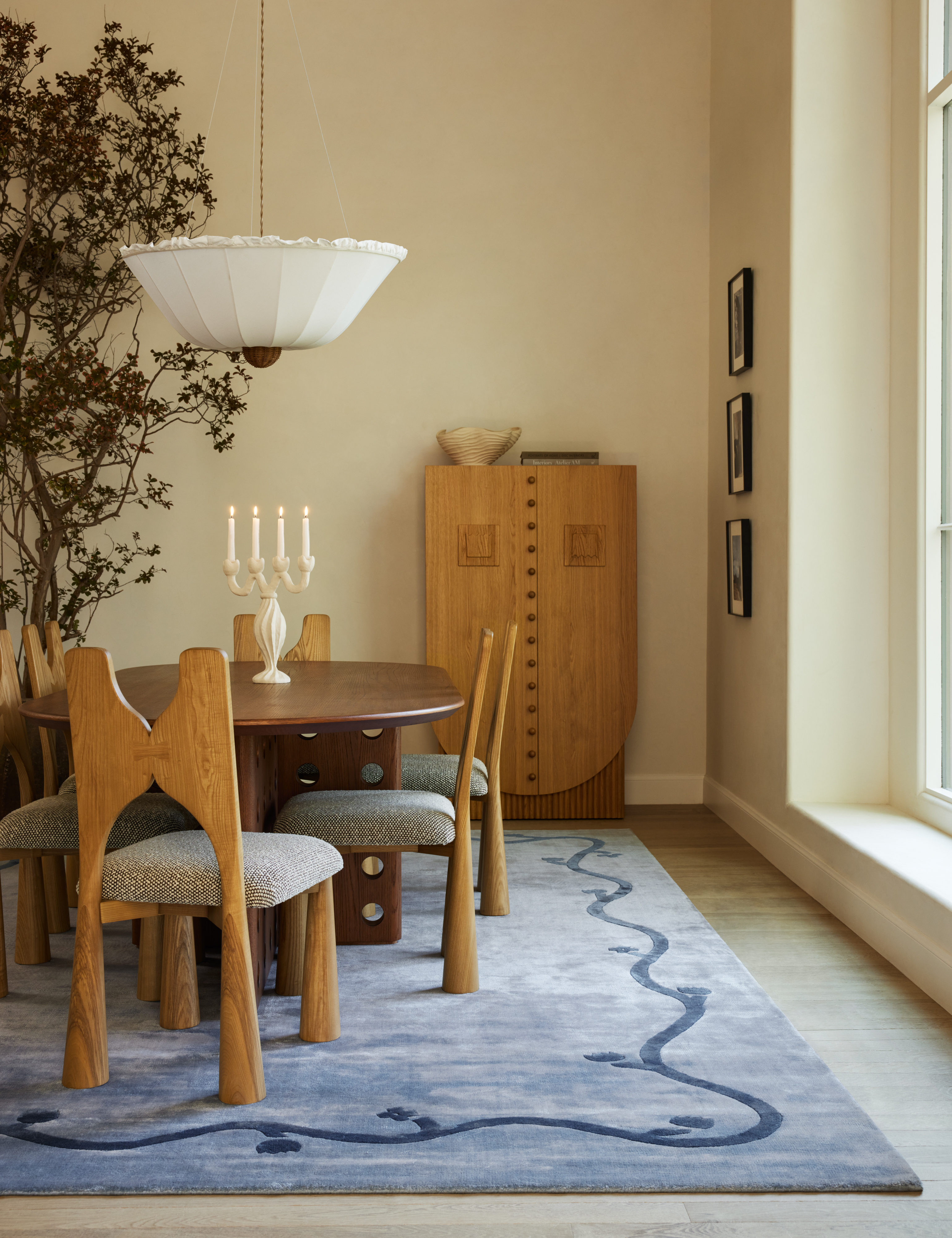 Dining room featuring a blue area rug, wooden fining furniture, and a twisted ceramic candelabra