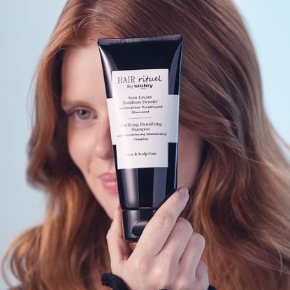 a woman using the Hair Rituel by Sisley duo