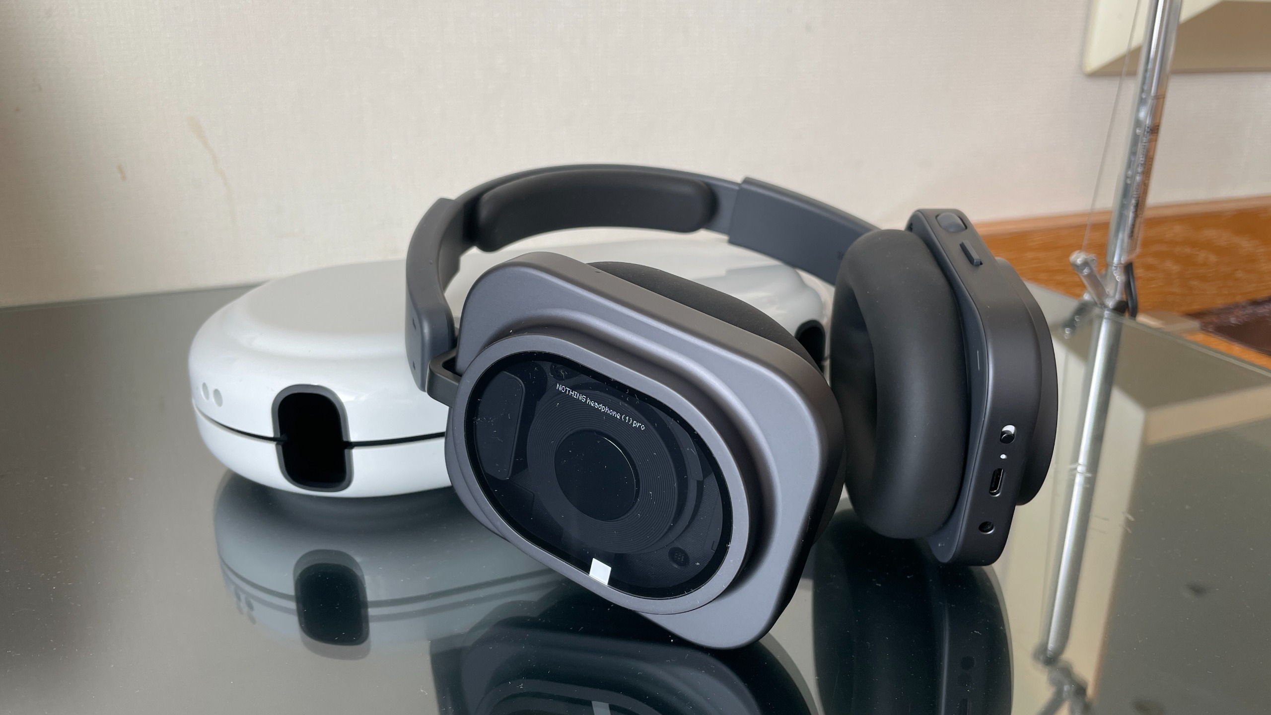 Nothing Headphone (1) Pro with the case on a shiny black and glass table
