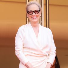 Meryl streep wearing glasses and an all white outfit. 