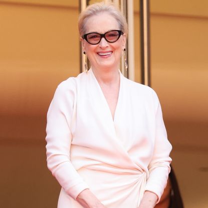 Meryl streep wearing glasses and an all white outfit. 