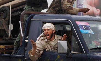 A Libyan rebel shouts in anger as his comrades withdraw Thursday: A NATO air strike may be at fault for the deaths of at least five rebels this week.