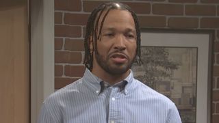 Jalen Brunson wears a button up shirt during an office sketch on SNL.