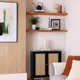 living room with white wall wooden shelf and black storage cabinet